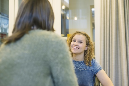 Een meisje in gesprek met een volwassene